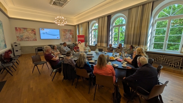 Das Bild zeigt Bürgermeister Eckhard Graf im Gespräch mit Freiwilligen der Nachbarschaftshilfe im Ratssaal des Ratzeburger Rathauses.