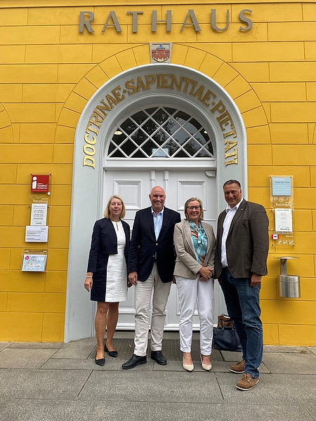 Das Bild zeigt Staatssekretärin Silke Schiller-Tobies in einer Gruppenaufnahme mit Kerstin Andresen, Regionalvorständin der Volksbank Raiffeisenbank eG, Stadtpräsident Andreas von Gropper, Staatssekretärin und Bürgermeister Eckhard Graf vor dem Ratzeburger Rathaus.